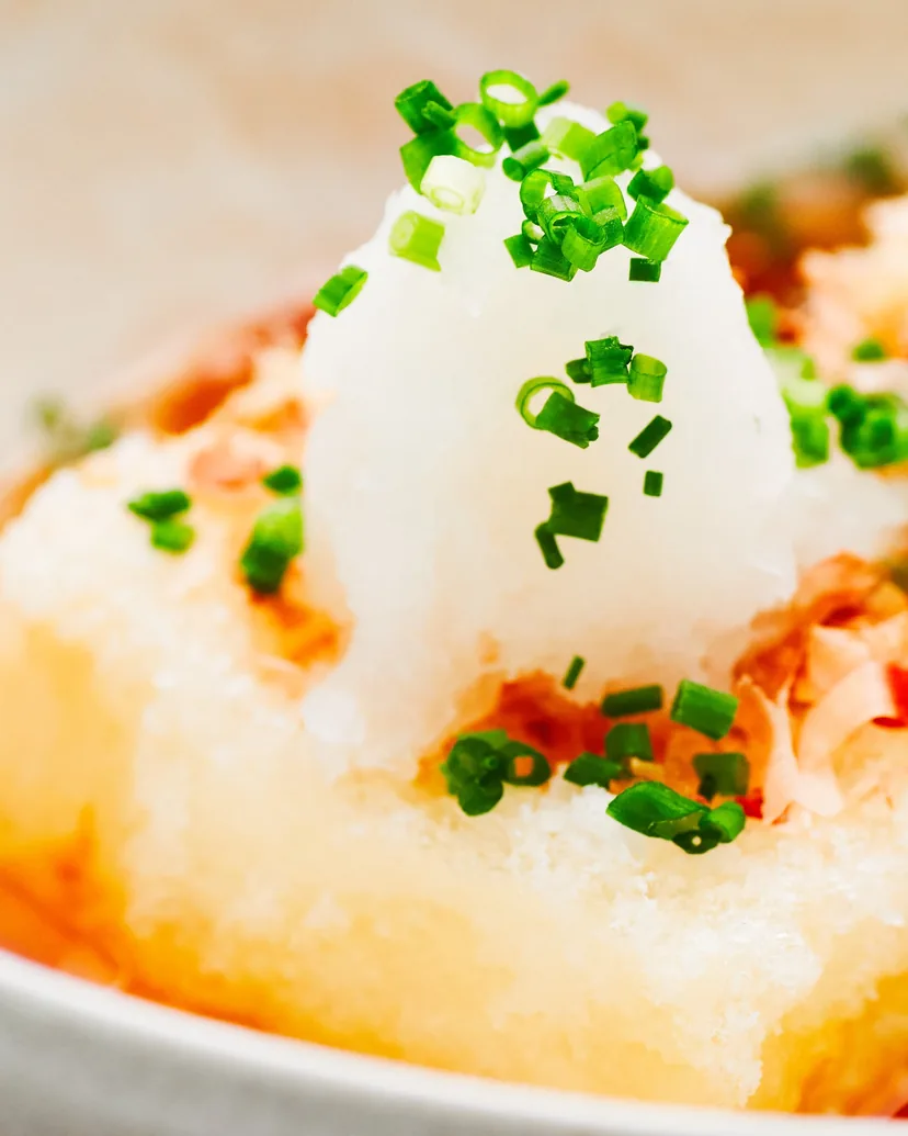 Fried tofu in dashi topped with grated daikon, bonito flakes and green onion