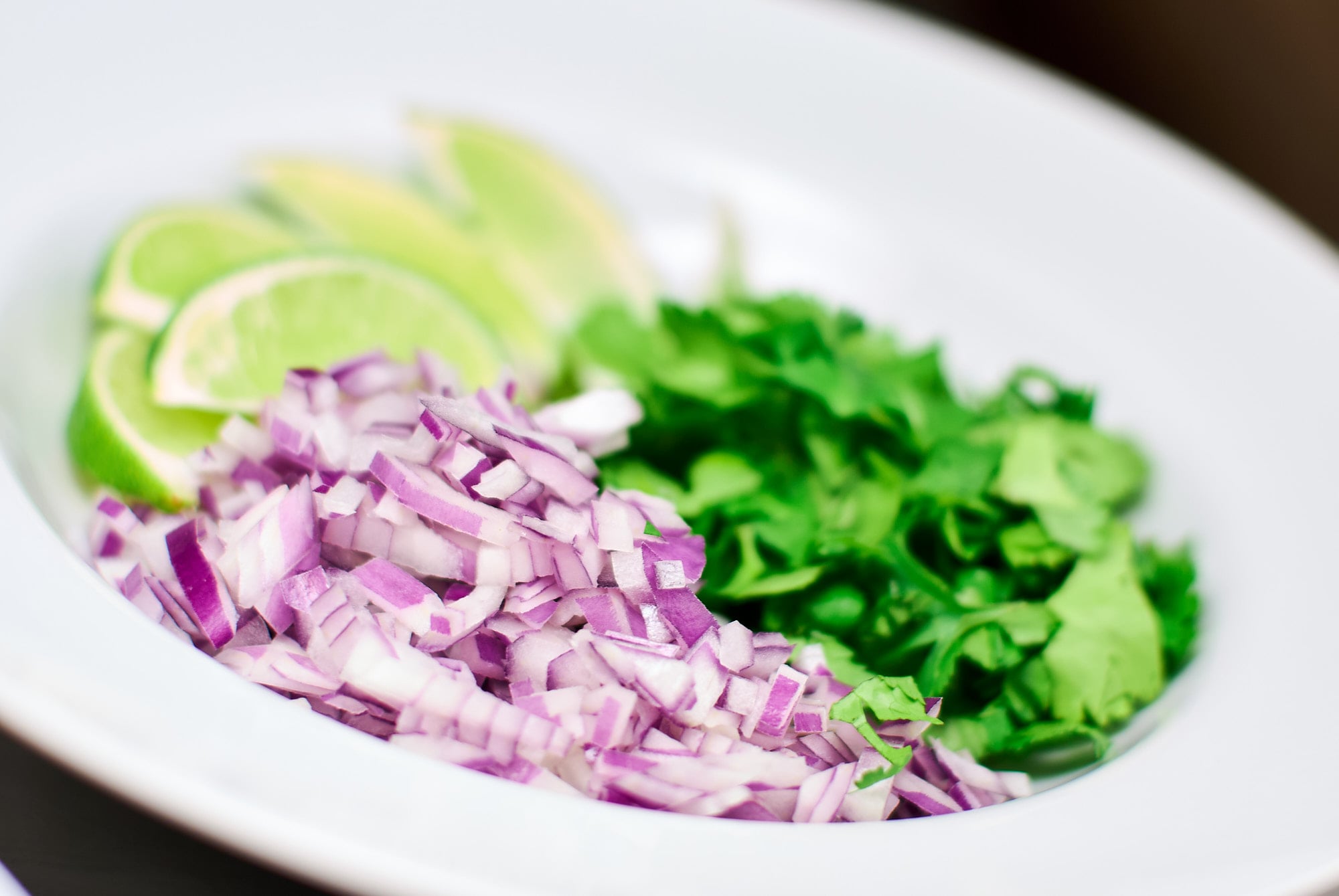 Red onion, cilantro and lime wedges for serving with Menudo.