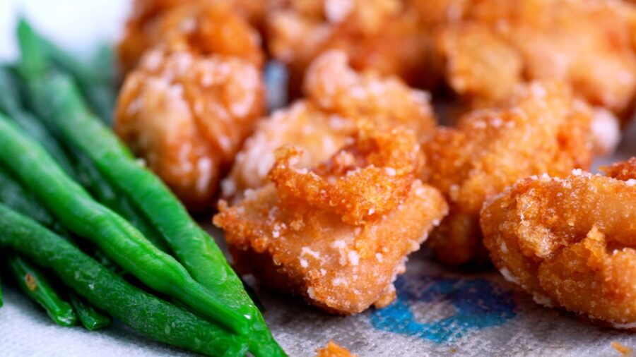 Fried chicken Karaage with green beans draining on paper towels.