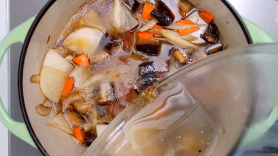 Adding shiitake dashi to vegan Japanese soup.