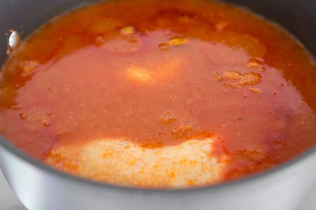 Chicken cooking in tomato sauce.