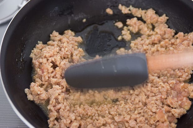 Crumbling the ground chicken.