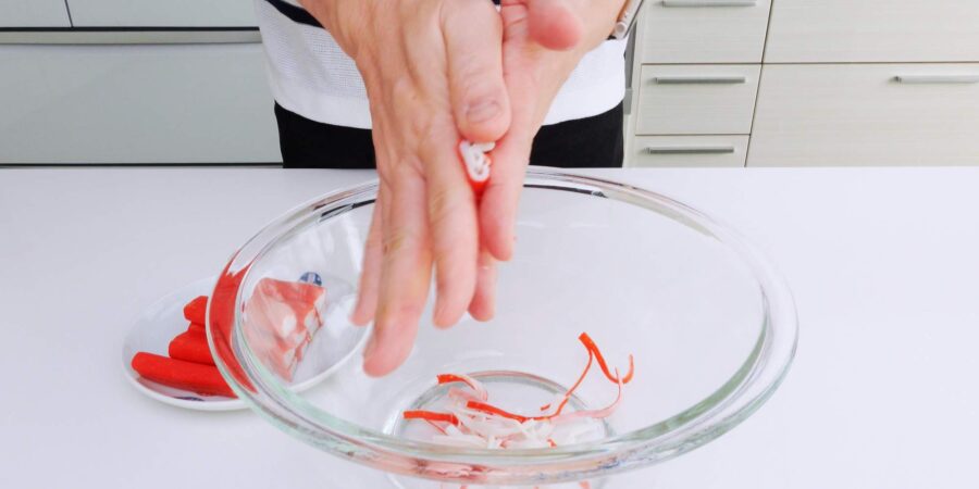 Shredding crab sticks by rolling between hands.