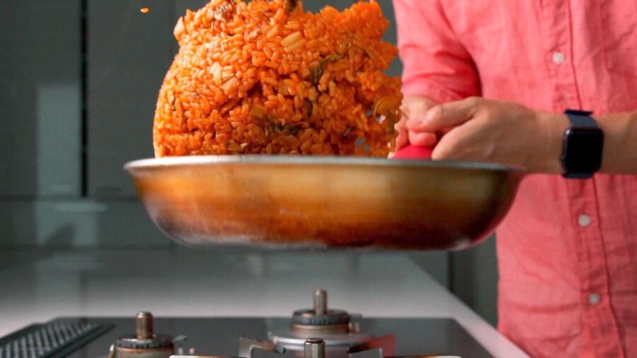 Tossing kimchi fried rice in a frying pan.