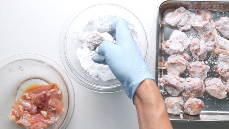 Dusting the marinated chicken in potato starch.