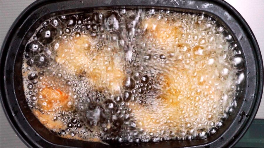 Frying the marinated chicken for orange chicken.