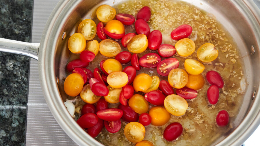 Deglaze the fond from the bottom of the pan using white wine and cherry tomatoes.