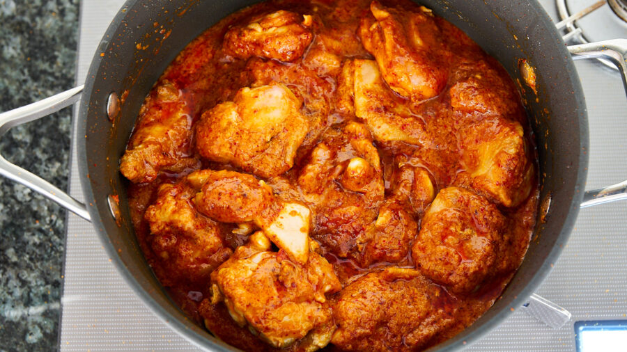 Add coconut milk and return the chicken to the rendang sauce.