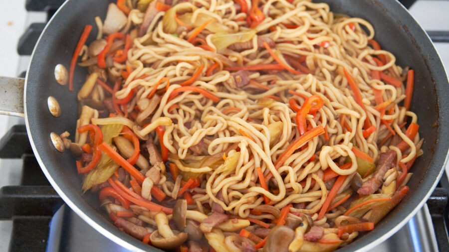 Stir-frying shirataki yakisboa in a frying pan.