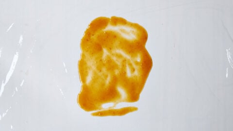 Thin layer of miso marinade spread on plastic wrap, ready to wrap and cure salmon.