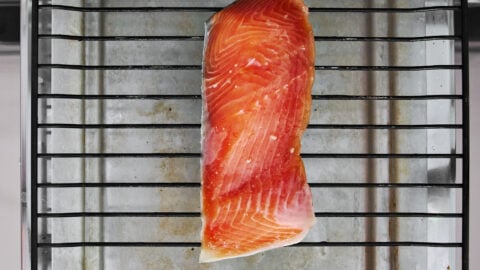 Cured miso salmon fillet on a wire rack under the oven broiler.
