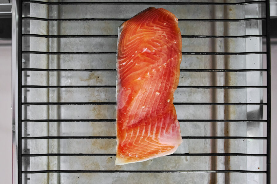 Cured miso salmon fillet on a wire rack under the oven broiler.