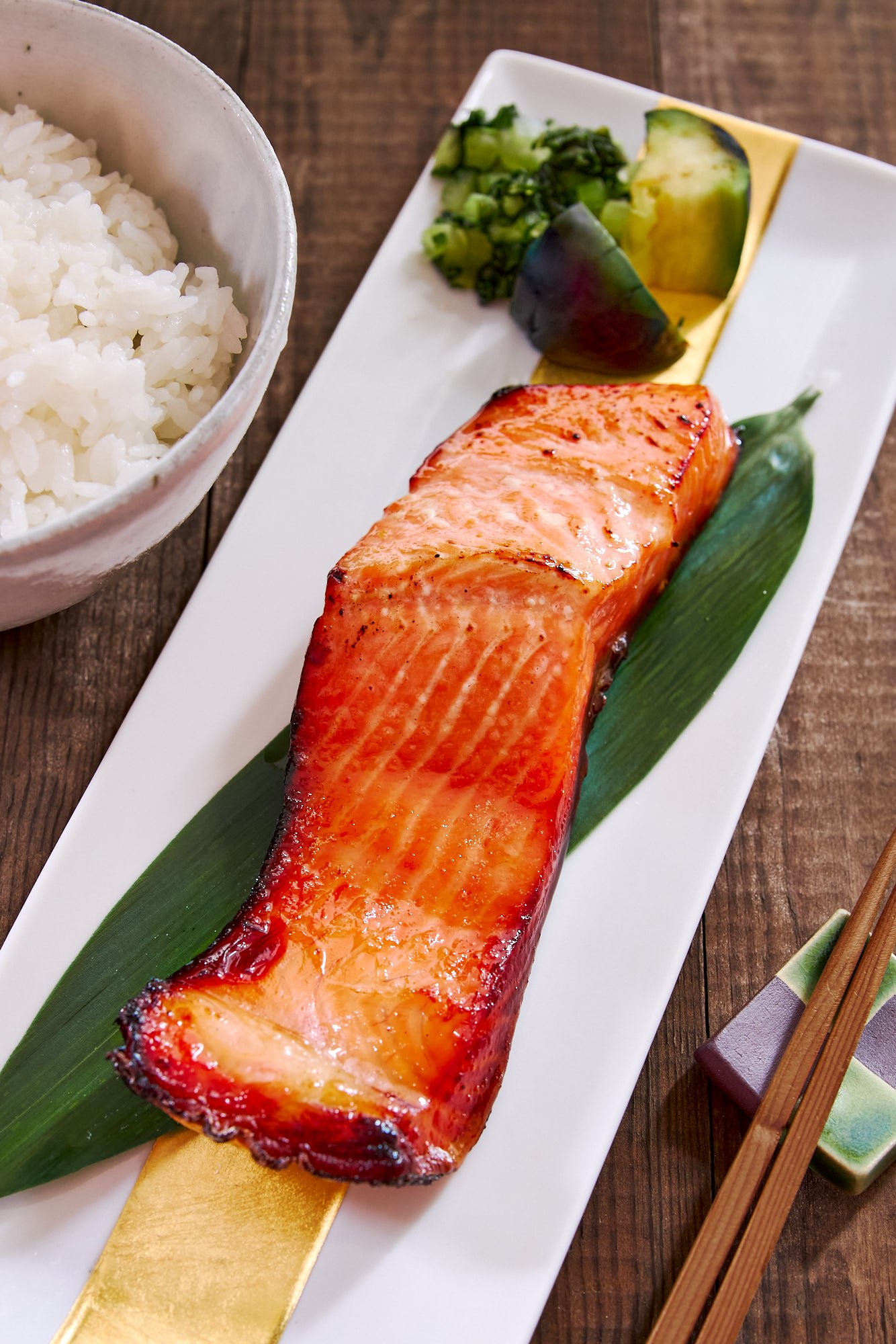 Plated Japanese miso salmon on a white rectangular plate with rice and pickles. - 1