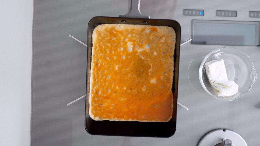 The first layer of egg in a Tamagoyaki pan.