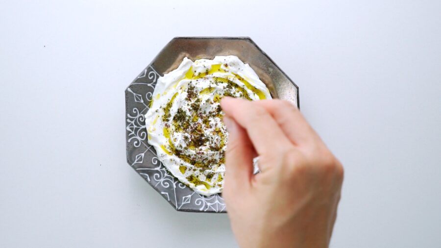 Sprinkling za'atar over Labneh.