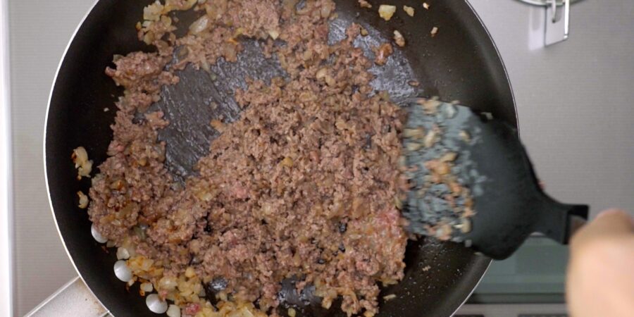 Ground beef cooking in a frying pan.