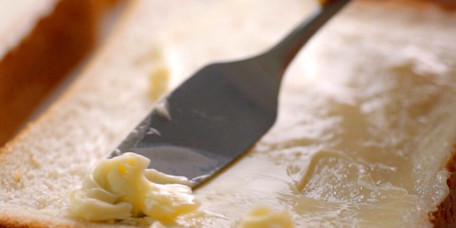 Spreading butter on sandwich bread.