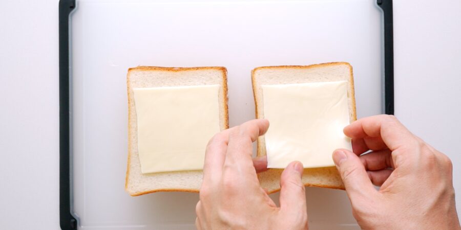 Adding a slice of American Cheese to sandwich bread for Curry Bread.