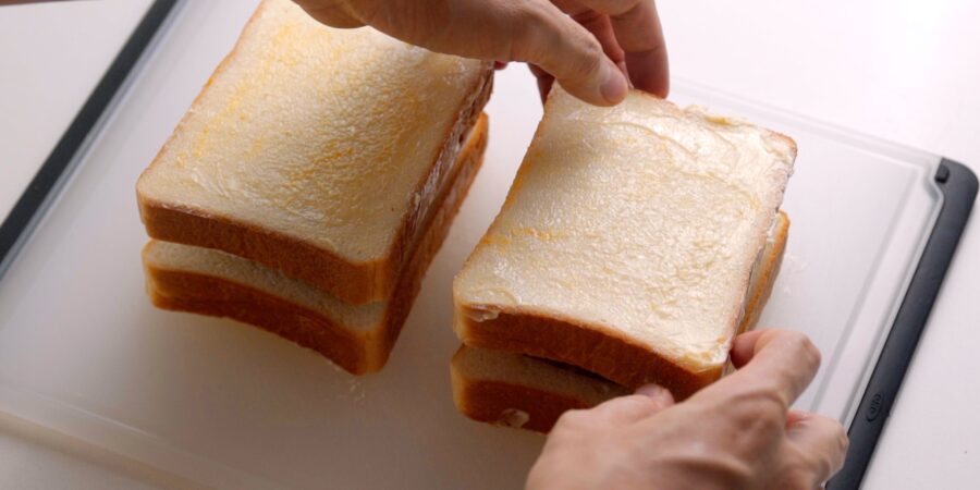 Topping the curry bread off with another slice of buttered bread.