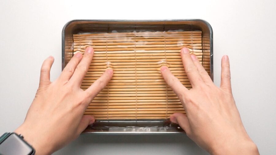 Soaking bamboo mat used to shape the Datemaki in water.