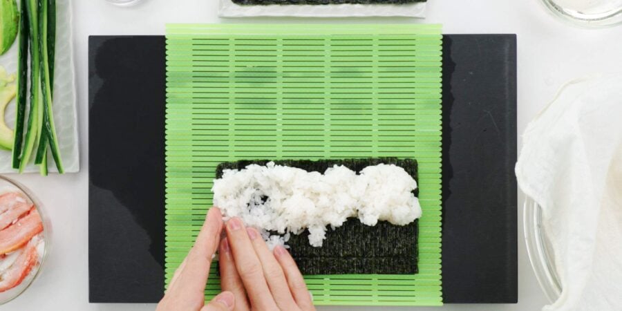 Spreading rice into nori for California roll.