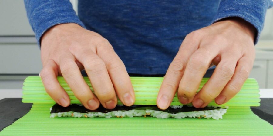 Forming the roll with a sushi mat.