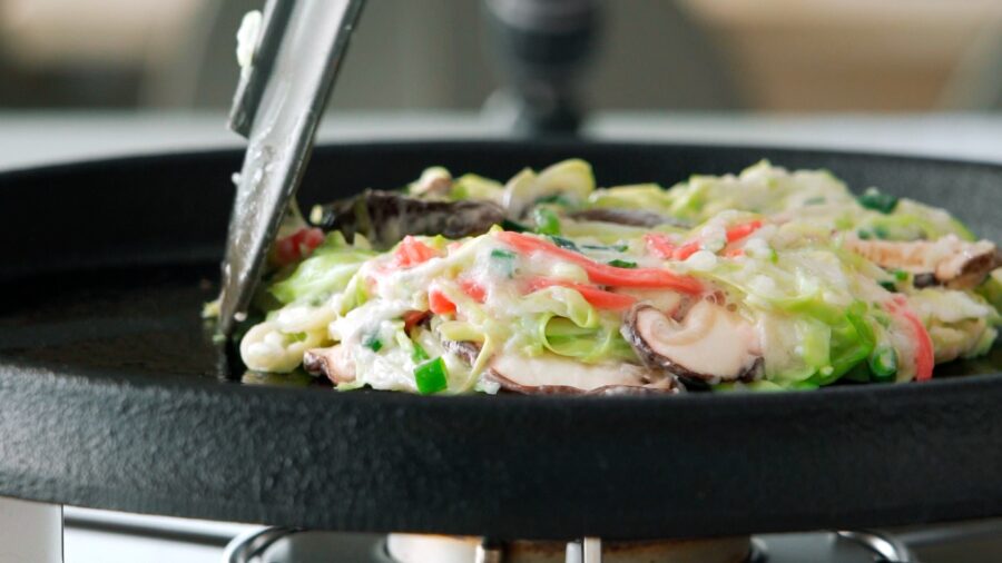Frying Okonomiyaki on a cast iron griddle.