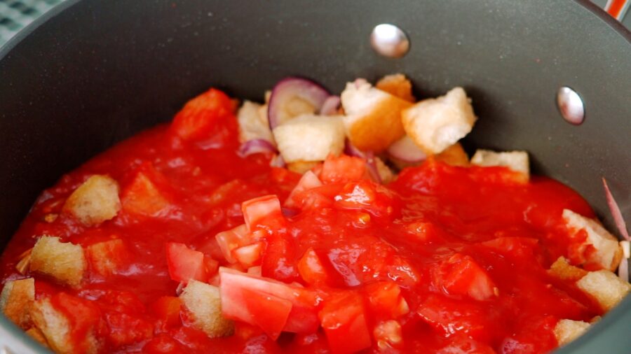 Adding tomatoes to sautéed bread.