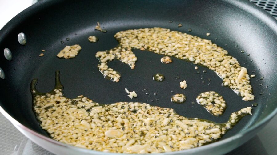 Garlic frying in olive oil for making chickpea pasta.