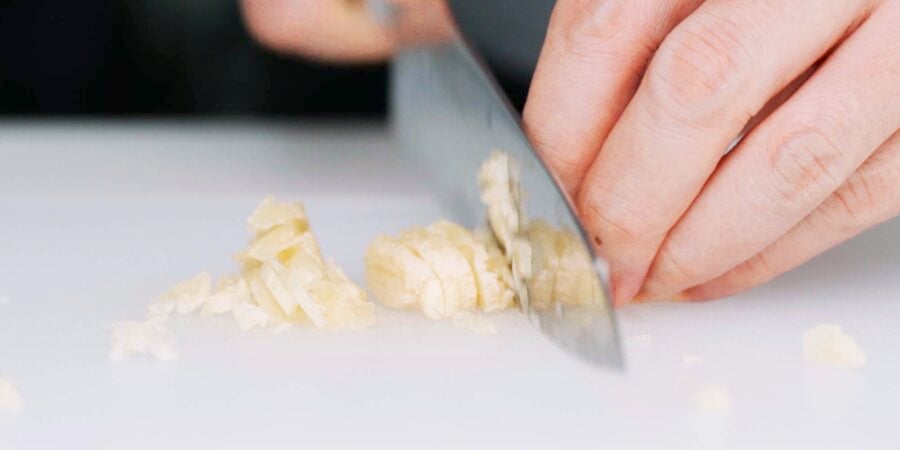Chopping smashed garlic.