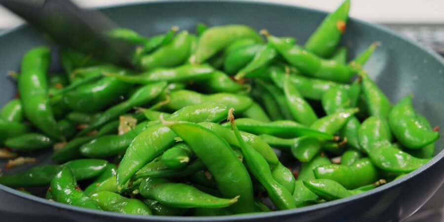 Garlic and edamame in a frying pan.