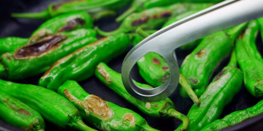 Dry-roasting shishito peppers.