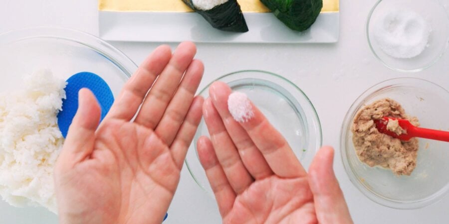 Wet your hands and then rub some salt between them to season the outside of the onigiri.