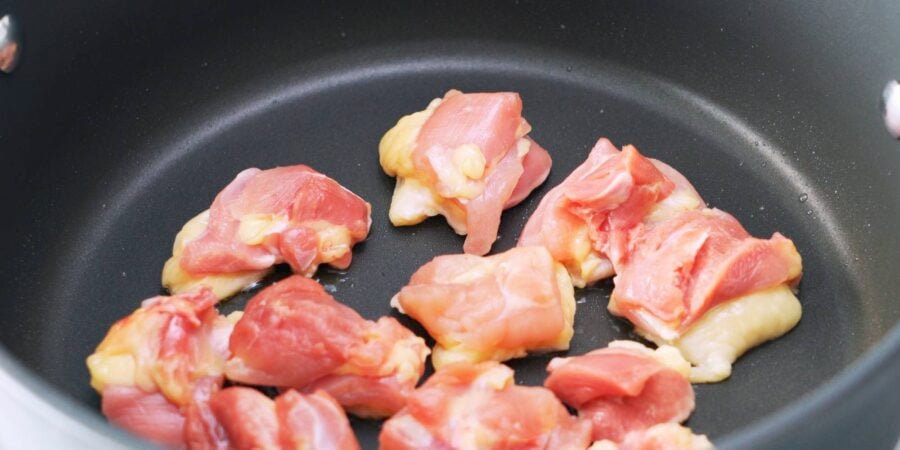 Chicken thighs frying in pan for udon noodles.