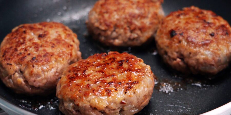 Browned Japanese hamburger steaks in a frying pan.