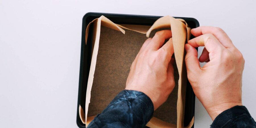 Lining a brownie pan with parchment paper.