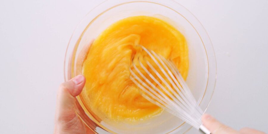 Whisking sugar and vanilla into melted butter and chocolate.