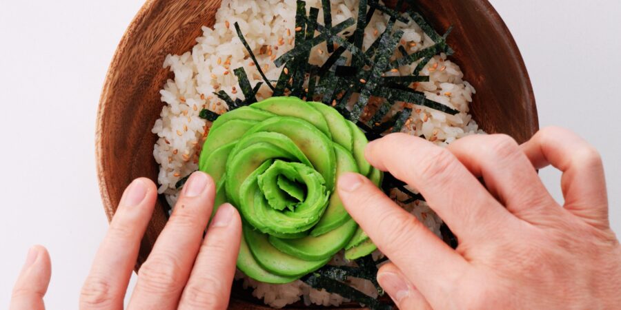 Avocado rose blooming on a sushi bowl.