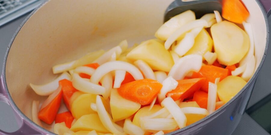 Sauteeing onions, carrots and potatoes for cream stew.