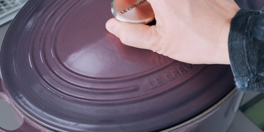 Covering purple dutch oven with a lid.