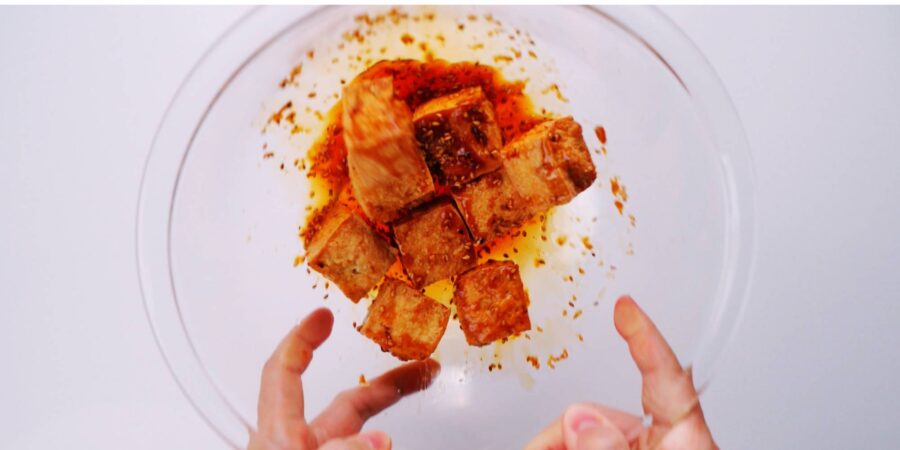 Tossing crispy tofu with ginger garlic glaze.
