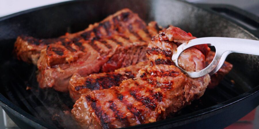 Hanger steaks with grill marks on grill pan.