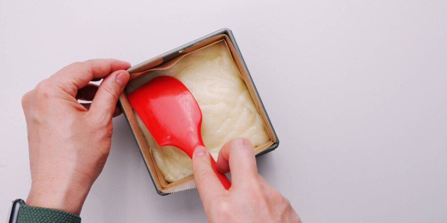 Pressing butter mochi into a mold.