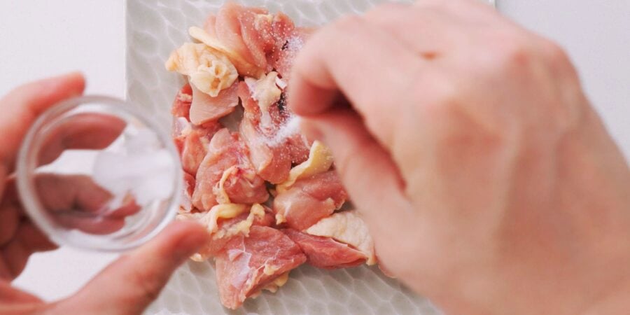 Salting chicken pieces.