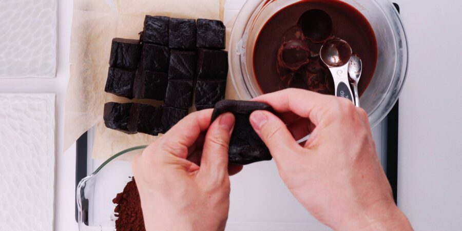 Flattening out chocolate mochi with fingers.