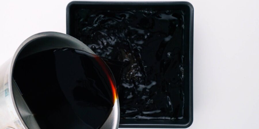 Pouring coffee jelly mix into a square mold.