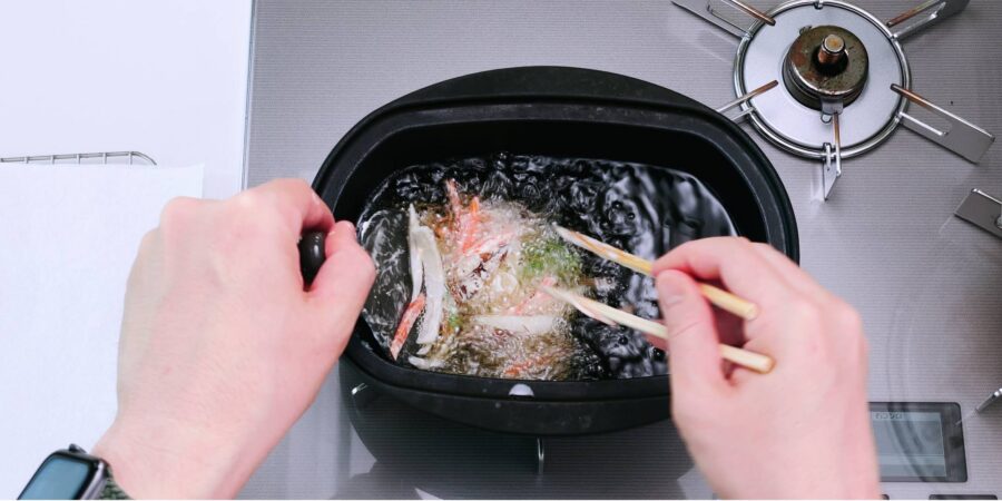 Adding kakiage tempura fritter to hot oil to deep-fry.