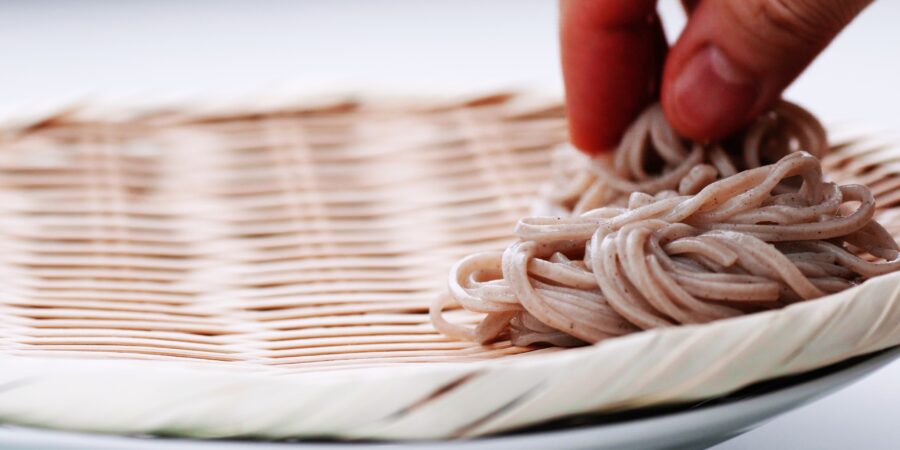 Making mounds of soba on a traditional bamboo zaru.