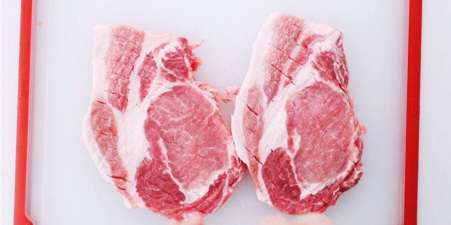 Pork chops pounded out with a mallet to tenderize and make thin cutlets.