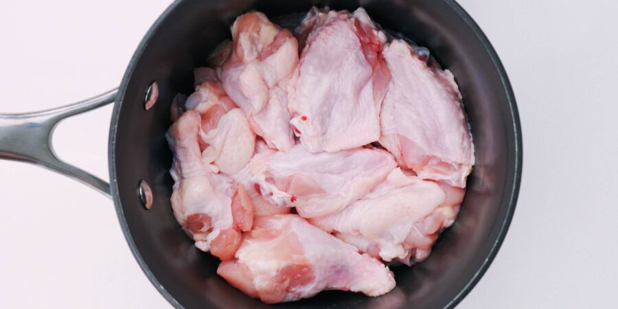 Chicken wings packed into a pot.